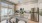 expansive kitchen with white cabinetry and kitchen island and quartz countertops