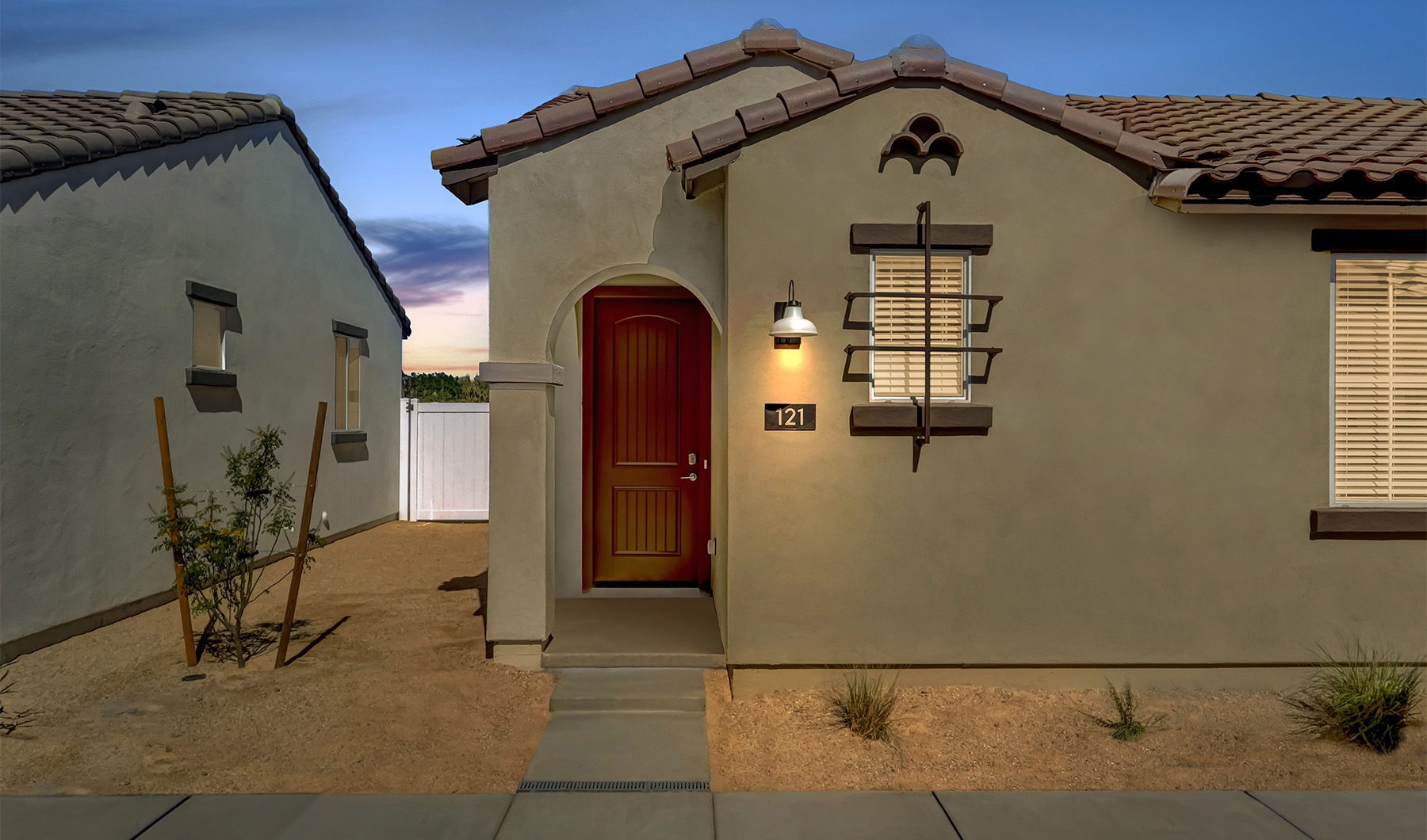 The exterior of a home with a gravel yard and shubbery