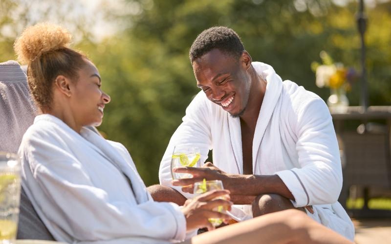 a man and a woman sitting at a table near a pool